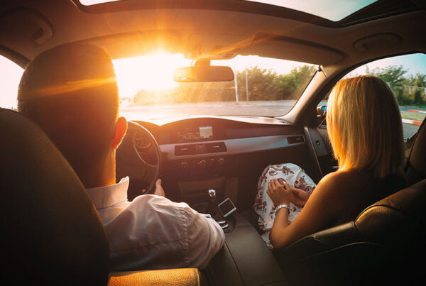 YouTurn-Program-Husband-and-Wife-Driving-in-their-New-Car-with-the-Sun-Coming-Through-the-Window