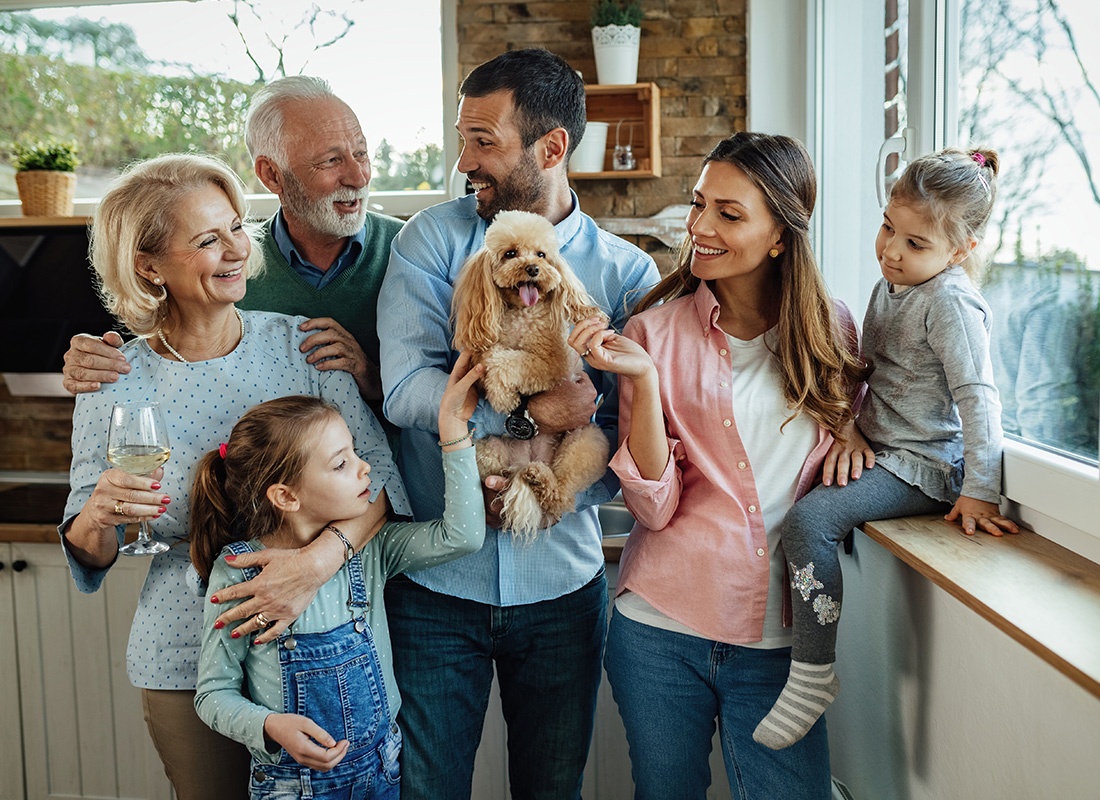 About Our Agency - Multi Generational Family With the Family Dog Smiling Together