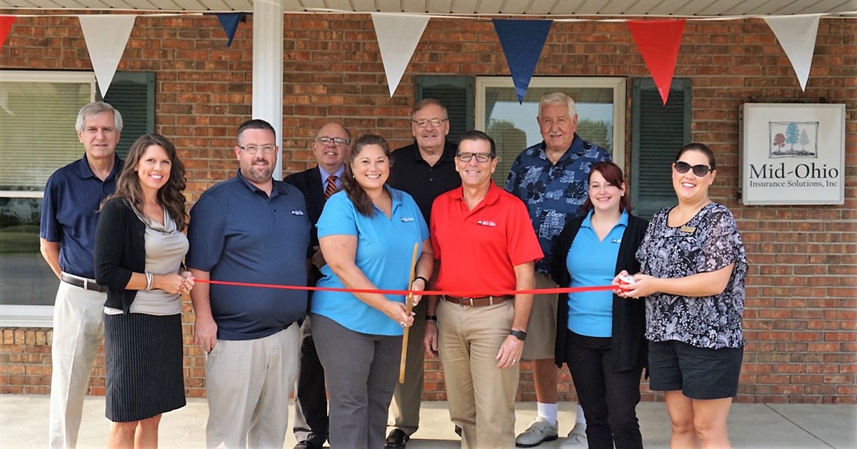 About Our Agency - MidOhio Insurance Solutions Team Standing Together in Front of Their Office as They Cut a Ribbon